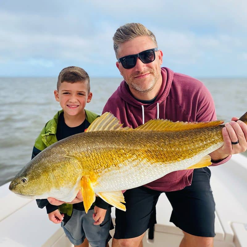 Young angler holding redfish on Cast Away fishing and boating charters in Beaufort SC