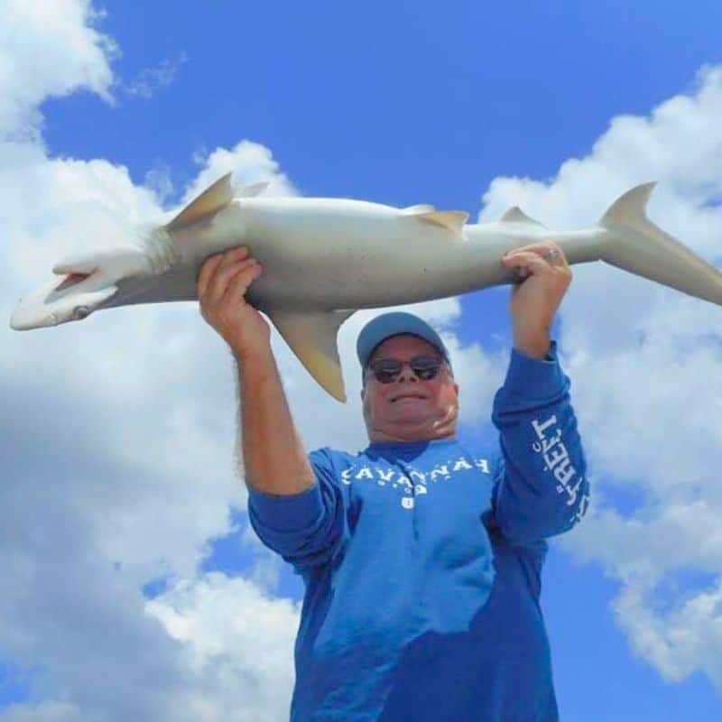 Angler lifting fish overhead on Sea Islands fishing charter