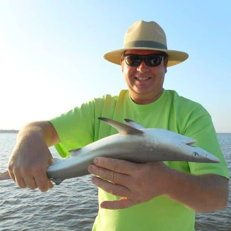 Man holding fish on Cast Away fishing and boating charter