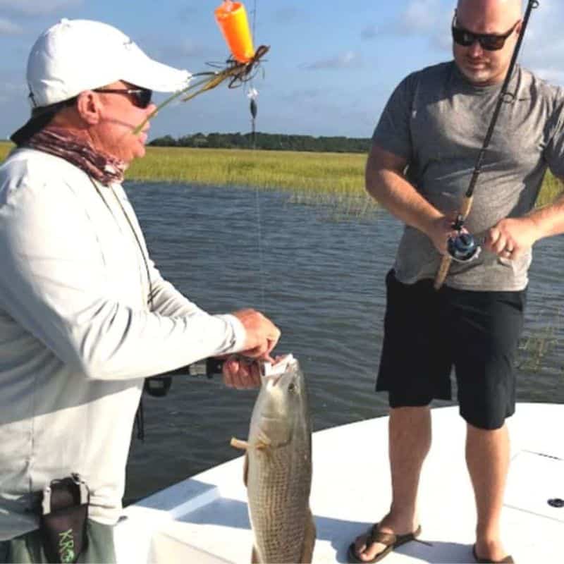 Fishing guide assisting angler on Lowcountry fishing charter