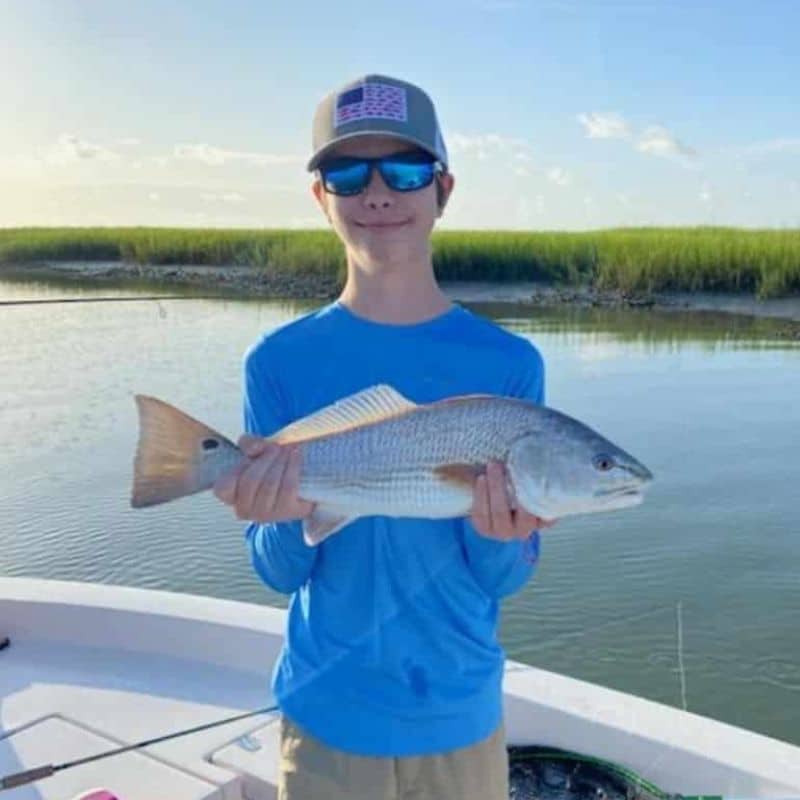 Young angler holding fish on Sea Islands fishing charter