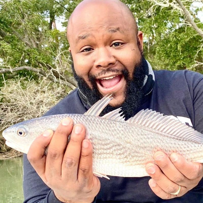 Man holding redfish on Beaufort SC fishing charter boat
