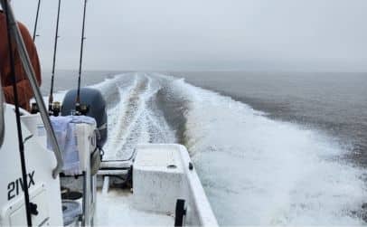 A boat cruising on the water with fishing poles