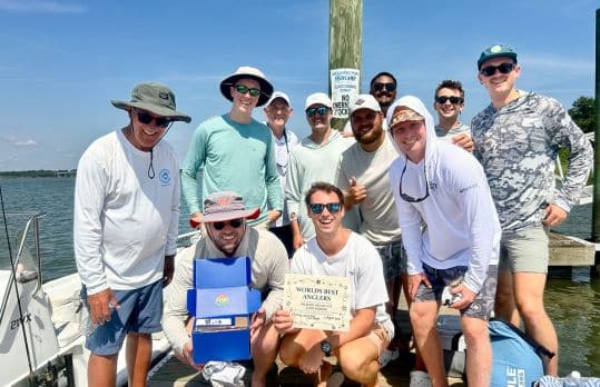 A group of men holding a certificate for winning Cast Away's fishing tourney
